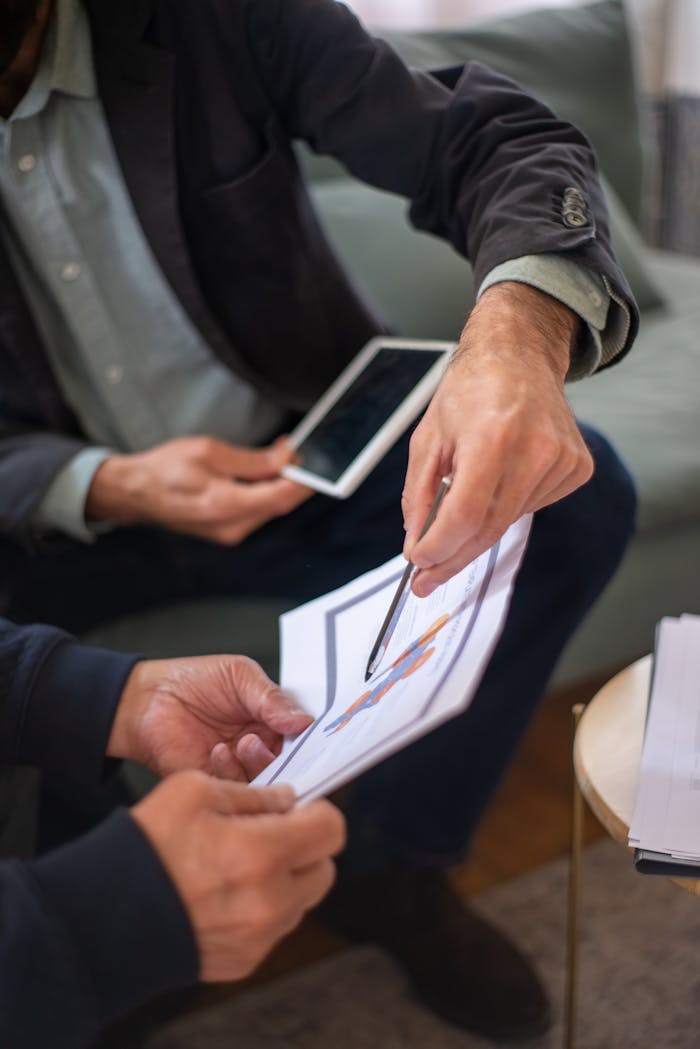 Man Holding a Pen Pointing on a Document